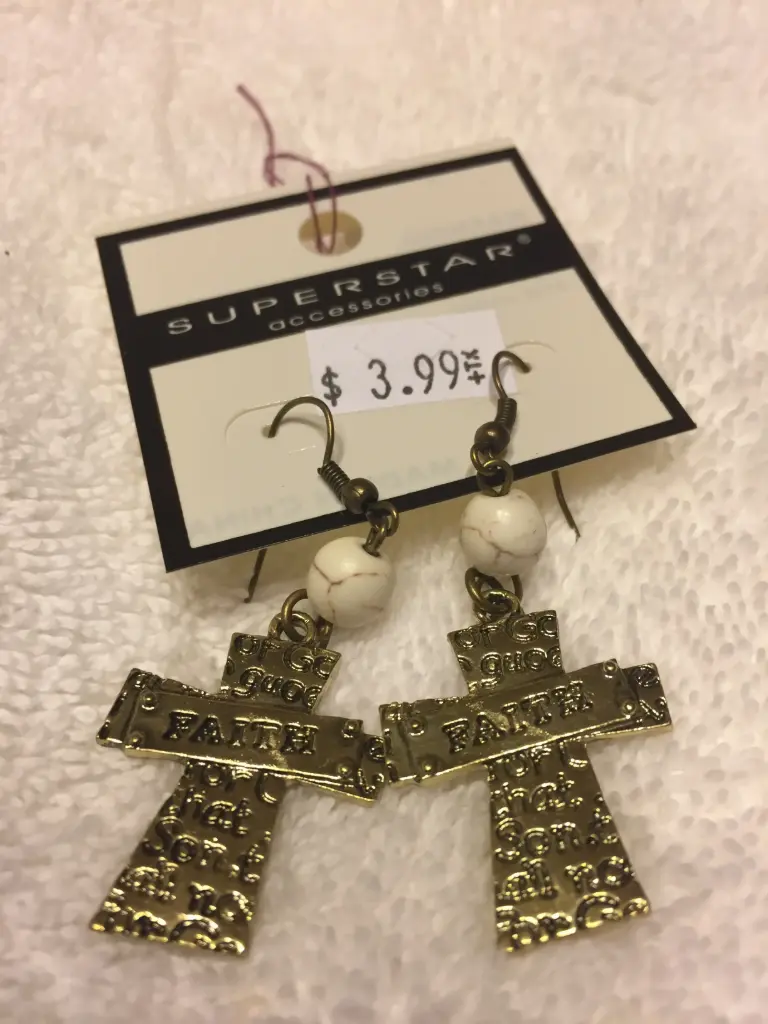 Burnished metal 'Faith' cross dangling earring. Color gold/white